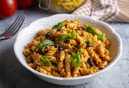 Téléchargez les photos : Basil leaves on pasta with arabiata sauce - en image libre de droit