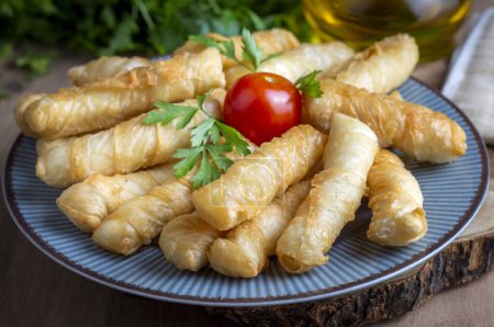 Photo for Fried pastry wrapped in cheese in phyllo. Pie in the form of a roll. Turkish name; Kalem borek - sigara boregi - Royalty Free Image