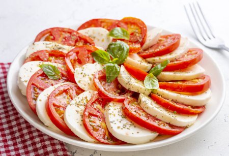 Photo for Italian caprese salad with sliced tomatoes, mozzarella, basil, olive oil - Royalty Free Image