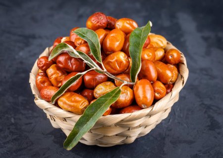 Téléchargez les photos : Fruits d'argenterie crus frais dans un bol avec un bouquet d'arbre d'argenterie, de levure ou d'olive russe (Elaeagnus ) - en image libre de droit