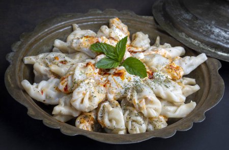 Photo for Traditional manti food on plate, top view. The concept of oriental cuisine. Uzbek food manty dumplings. (Turkish name; hinkel mantisi) - Royalty Free Image