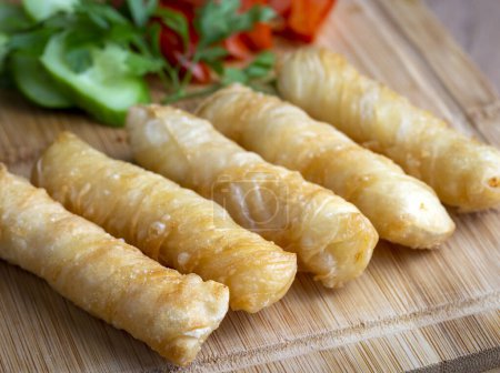 Foto de Fried pastry wrapped in cheese in phyllo. Pie in the form of a roll. Turkish name; Kalem borek - sigara boregi - Imagen libre de derechos