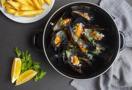 Téléchargez les photos : Delicious seafood mussels with parsley sauce and lemon. Delicious steamed mussels - en image libre de droit
