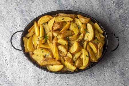 Photo for Roasted potato wedges with herbs and sea salt on plate, top view (Turkish name; elma dilim patates) - Royalty Free Image