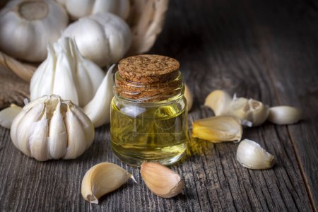 Photo for Garlic with olive oil on wooden background - Royalty Free Image