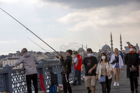 Foto de Estambul - Turquía, 18 de febrero de 2021, Pescador y pueblos en el puente de Galata - Imagen libre de derechos