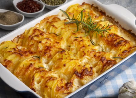 Photo for Potato gratin - graten (baked potatoes with cream and cheese) with rosemary and forks (Turkish name; Kremali patates) - Royalty Free Image