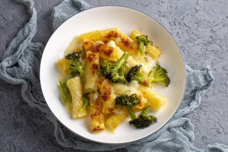 Téléchargez les photos : Pâtes cuites avec du brocoli et du poulet. Brocoli, fromage et sauce gratinée sur pâtes penne cuites au four. - en image libre de droit