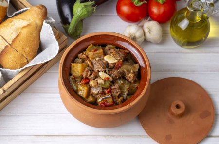 Téléchargez les photos : Vue du dessus du plat turc Guvech - viande cuite au four avec aubergine et traditionnellement servie en pot de faïence (nom turc ; etli patlican guvec ou patlican tava) - en image libre de droit