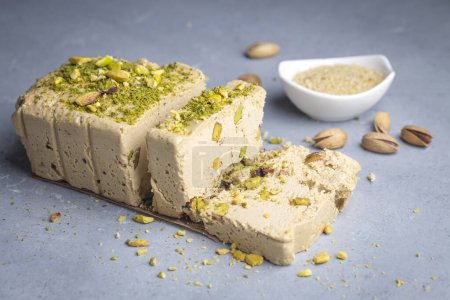 Photo for Sesame halva with pistachios on grey background. Top view. Copy space. Traditional middle eastern sweets. Jewish, turkish, arabic national dessert. Turkish delight. - Royalty Free Image