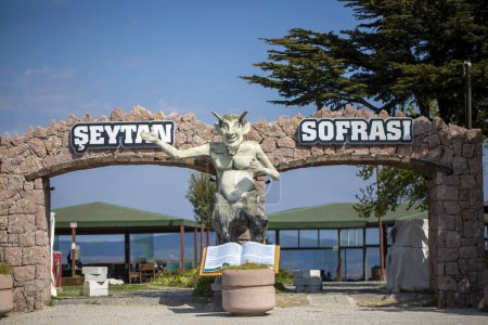 Foto de Isla Cunda, Ayvalik, Turquía. Marzo 26, 2023: Seytan Sofrasi Conocida como la Entrada de la Mesa de Satanás con la Estatua del Diablo. - Imagen libre de derechos