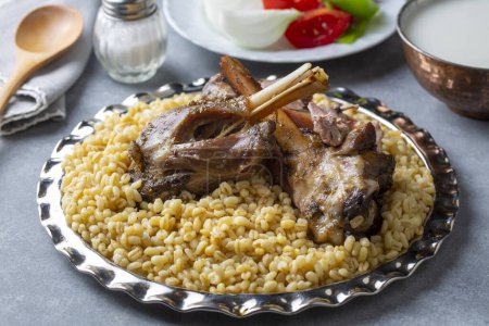 Photo for Turkish foods; lamb shank tandoori on bulgur wheat rice (Turkish name; bulgur bugday pilavi kuzu incik tandir) - Royalty Free Image