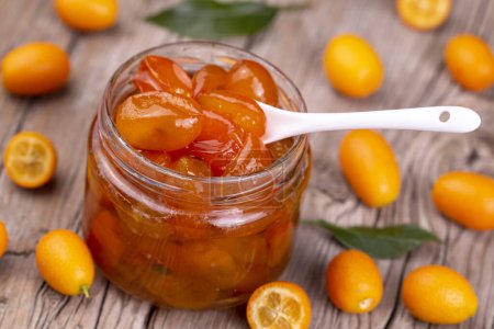 Photo for Homemade kumquat jam in jar and fresh kumquats, top view - Royalty Free Image