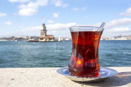 Téléchargez les photos : Magnific view of Maiden's Tower (aka Kiz kulesi) and traditional turkish tea on the front. Istanbul attractions. - en image libre de droit