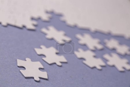 Photo for Missing jigsaw puzzle pieces. Business concept. Fragment of a folded white jigsaw puzzle and a pile of uncombed puzzle elements against - Royalty Free Image