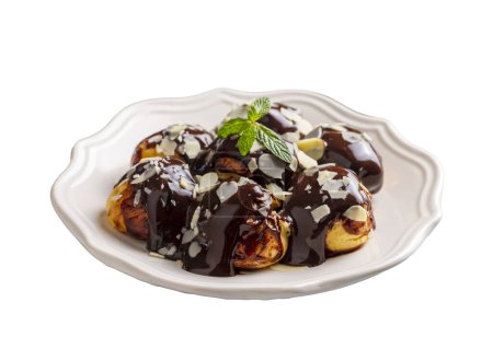 Photo for Delicious profiteroles with chocolate and white plate. Selective focus image on light background. - Royalty Free Image