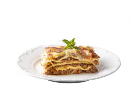 Téléchargez les photos : Portion of ground beef lasagna topped with melted cheese and garnished with fresh parsley served on a plate in close view for a menu - en image libre de droit