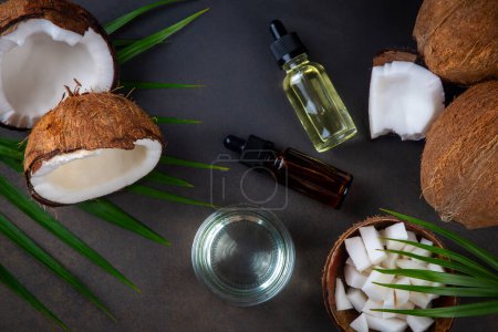 Photo for Bottle of coconut oil and fresh coconuts with palm leaf - Royalty Free Image