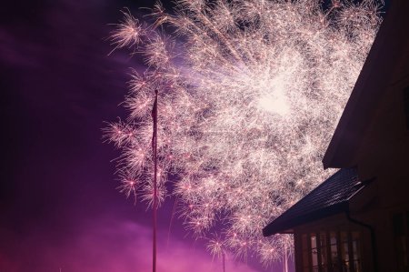 Foto de New year eve fireworks above the houses. - Imagen libre de derechos