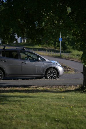 Téléchargez les photos : Tonsberg, Norvège - 2 juin 2023 : gris argenté NISSAN LEAF est une voiture électrique compacte du segment C. Nouvelle voiture par une journée ensoleillée d'été - en image libre de droit
