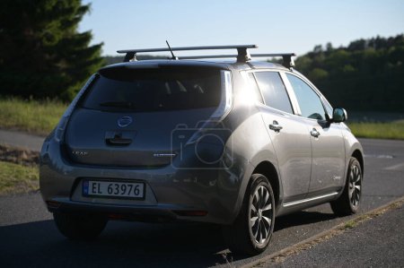 Foto de Tonsberg, Noruega - 2 de junio de 2023: gris plata NISSAN LEAF es un automóvil eléctrico compacto del segmento C. Coche nuevo en un soleado día de verano - Imagen libre de derechos