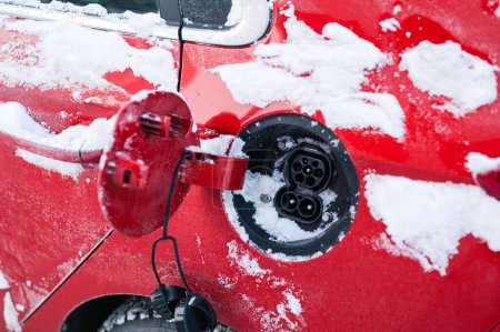 Téléchargez les photos : Tonsberg, Norvège - 27 décembre 2023 : Hyundai Ioniq rouge orangé recharge une voiture électrique près de la borne de recharge - en image libre de droit