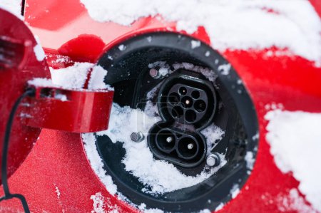 Téléchargez les photos : Tonsberg, Norvège - 27 décembre 2023 : Hyundai Ioniq rouge orangé recharge une voiture électrique près de la borne de recharge - en image libre de droit