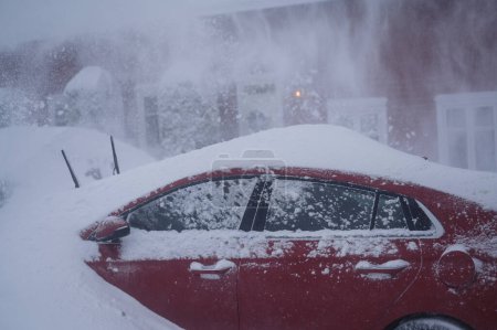 Téléchargez les photos : Tonsberg, Norvège - 1er janvier 2024 : Hyundai Ioniq rouge orangé sous la neige. Tempête de neige. Enlever la neige par souffleuse à neige - en image libre de droit