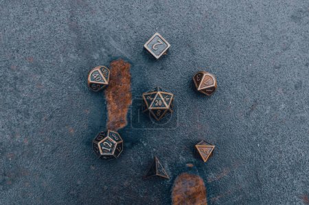 Overhead view of a set of ttrpg gaming dice on a metallic surface