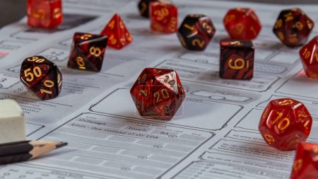 Photo for Close-up image of a set of red RPG gaming dice on a character sheet - Royalty Free Image