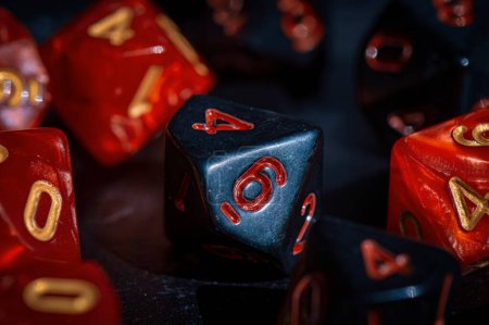 Photo for A close-up image of a black 10-sided die with red numbers - Royalty Free Image