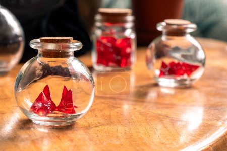 Photo for Three glass jars with red dice, meticulously arranged on a well-worn wooden table, offering a glimpse into a gamer's vintage collection - Royalty Free Image