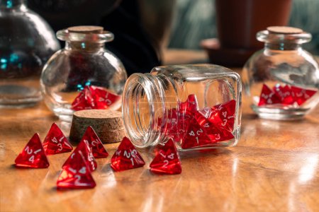 Téléchargez les photos : Dés rouges renversés d'un bocal en verre sur une table en bois rustique, capturant un moment de jeu dans un élégant désarroi - en image libre de droit