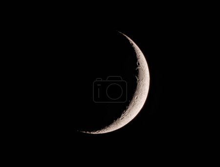 The crescent moon shines brightly in the night sky, casting a soft glow of moonlight. This astronomical object is a celestial event that can be observed at midnight