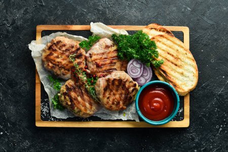Téléchargez les photos : Barbecue : boulettes de viande grillées enveloppées dans du bacon avec épices et sauce. Sur une planche de pierre. Vue du dessus. - en image libre de droit