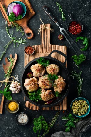 Photo for Grilled Juicy Turkey Cutlets. In a pan with spices and herbs. On a black stone background. Top view. - Royalty Free Image