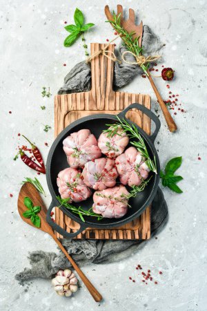 Photo for Turkey fillet with spices and rosemary in a pan, ready to cook. Barbecue. On a black concrete background. Top view. - Royalty Free Image