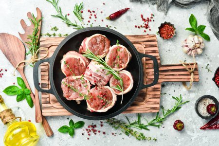 Photo for Pork tenderloin medallions wrapped in bacon. in a pan, ready to cook. On a concrete background. Top view. - Royalty Free Image