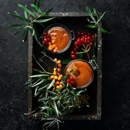 Photo for Jam. Viburnum berries and sea buckthorn with honey. Foods with a high content of vitamin C. On a dark background. top view - Royalty Free Image