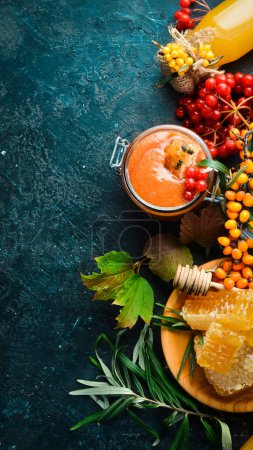 Photo for Jam. Viburnum berries and sea buckthorn with honey. Foods with a high content of vitamin C. On a dark background. top view - Royalty Free Image