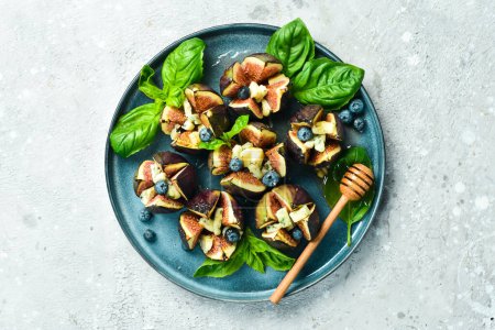 Photo for Baked figs with cheese, honey and nuts. In a plate. Top view. - Royalty Free Image