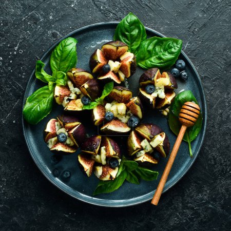 Photo for Homemade baked figs with blue cheese, honey and nuts. In a black bowl. Top view. - Royalty Free Image