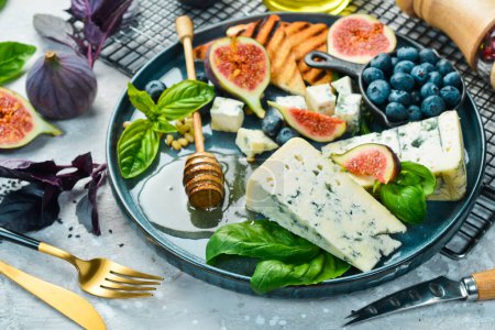 Photo for Traditional blue cheese, figs, blueberries and honey in a plate. On a concrete background. Side view. - Royalty Free Image