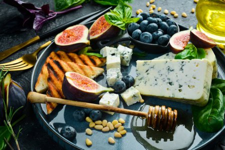 Photo for Blue cheese, figs, blueberries and honey on a plate. On a concrete background. Top view. - Royalty Free Image