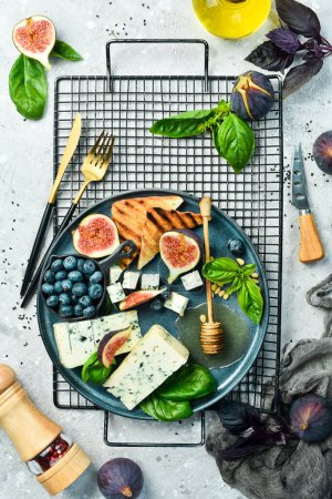 Photo for Blue cheese on a plate with basil and honey. On a concrete background. Top view. - Royalty Free Image