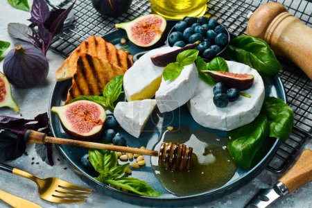 Photo for Brie cheese, with honey and figs, side view. On a concrete background. - Royalty Free Image