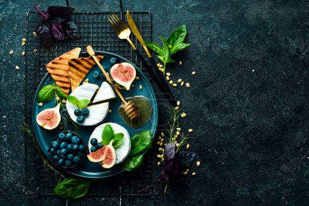 Photo for A plate with Brie cheese, with honey and figs. On a concrete background. Top view. - Royalty Free Image