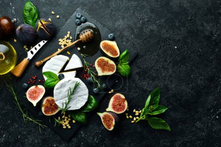 Photo for Cheese plate. Brie cheese, fresh figs and honey on stone board. Space for text. Top view. - Royalty Free Image