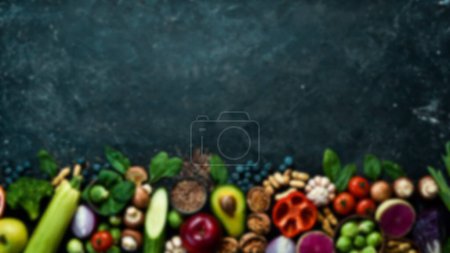 Téléchargez les photos : Contexte alimentaire déconcentré. Une nourriture saine. Légumes, fruits et aliments. Sur un fond en bois noir. Vue de dessus. Espace de copie. - en image libre de droit