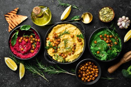 Photo for Colorful hummus bowls. Flat-lay of various vegetarian dips hummus. On a concrete black background. - Royalty Free Image